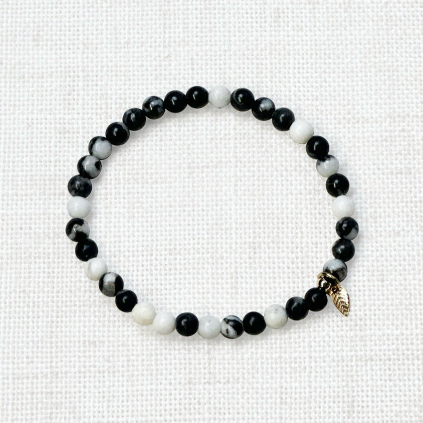 Zebra jasper crystal bracelet stacked with gold-toned jewelry
