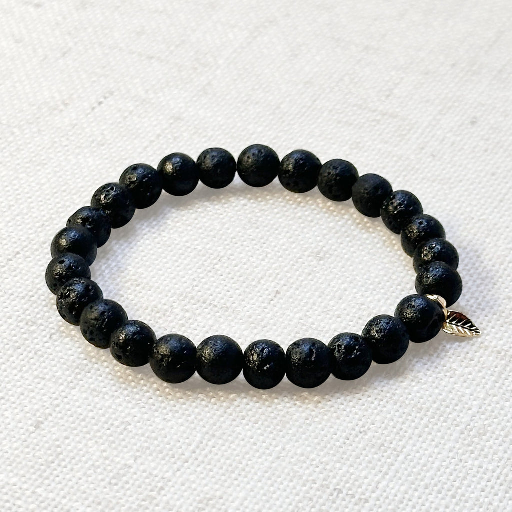 Lava stone bracelet close-up showing porous beads and symbolic charm