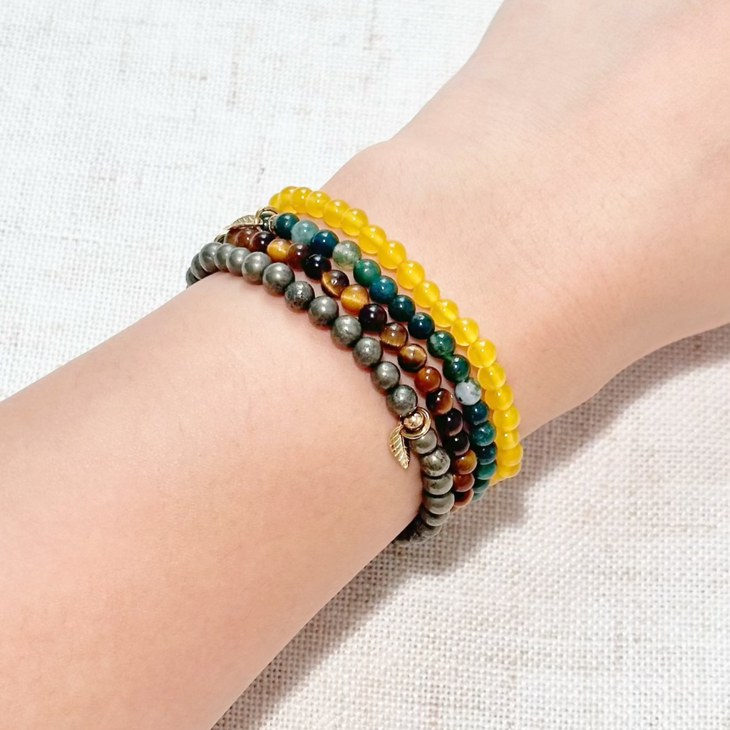 Close-up of gemstone bracelets promoting motivation, confidence, and financial growth.