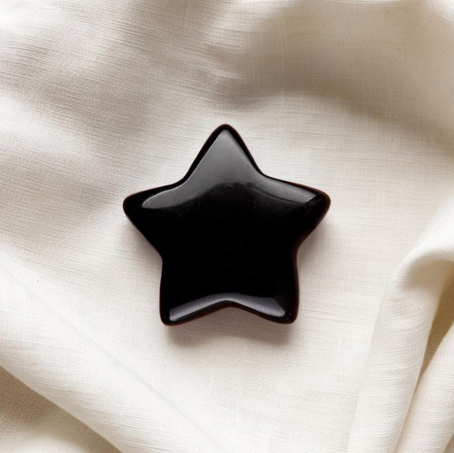 Hand-polished Black Obsidian crystal worry stone shaped like a star, perfect for focus, grounding, and energy shielding.