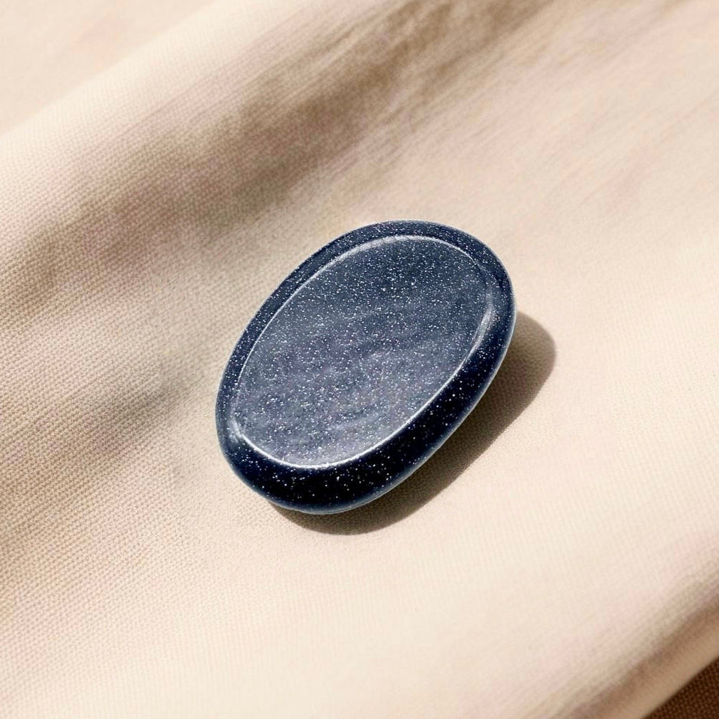 Polished Blue Goldstone crystal worry stone in a thumb shape, promoting motivation, focus, and positivity.