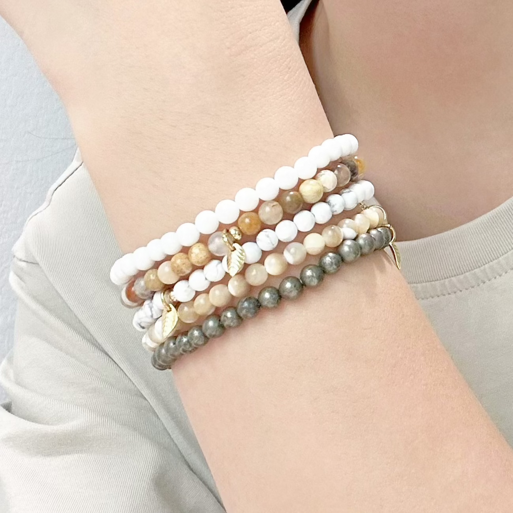 Crystal bracelet set laid on linen fabric, showcasing ocean-inspired colors and minimalist design.