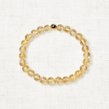 Citrine bracelet with natural golden-yellow gemstones on neutral background