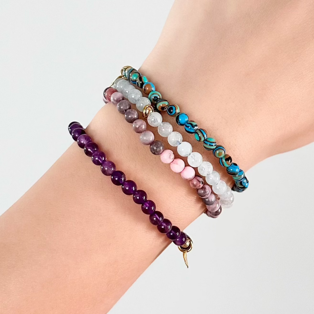Stacked Pisces zodiac crystal bracelets with soft pastel and oceanic hues