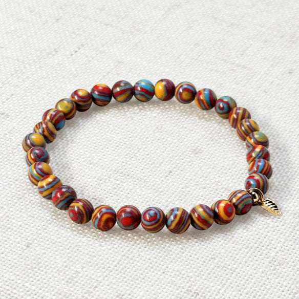 Colorful synthetic malachite bracelet styled with gold charm for positivity and growth