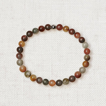 Rutilated quartz bracelet with golden charm on soft fabric