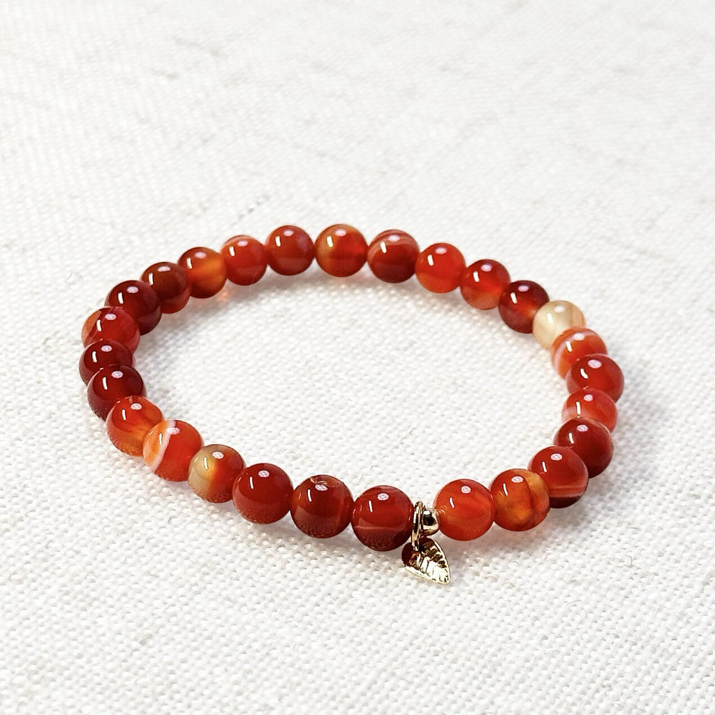 Sardonyx bracelet 6mm with golden leaf charm on display