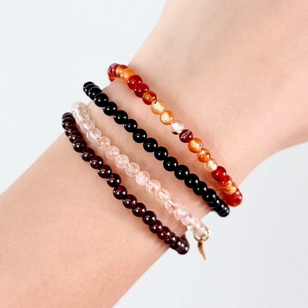 Crystal bracelets for Scorpio stacked with rich red and dark tones