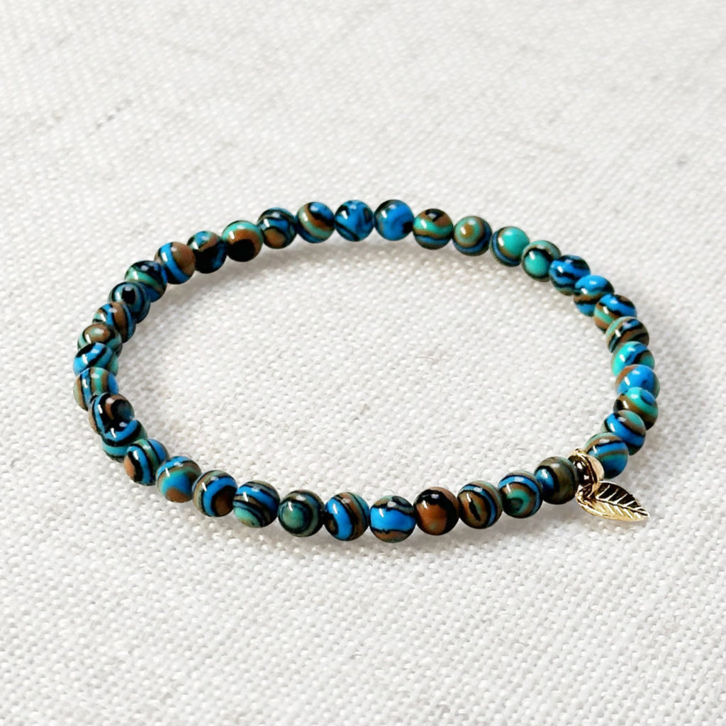 Minimalist crystal bracelet featuring synthetic blue malachite and golden accent