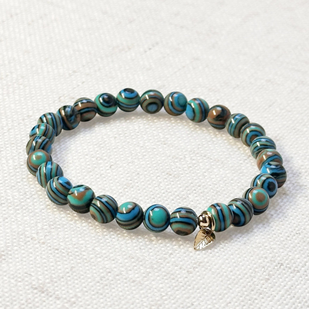 Crystal bracelet featuring blue malachite beads and gold leaf charm for meaningful gifting