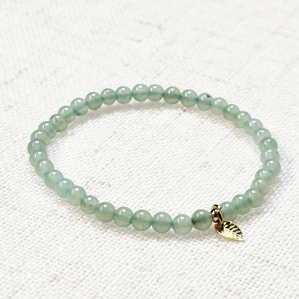 Close-up of green aventurine bracelet styled with neutral tones