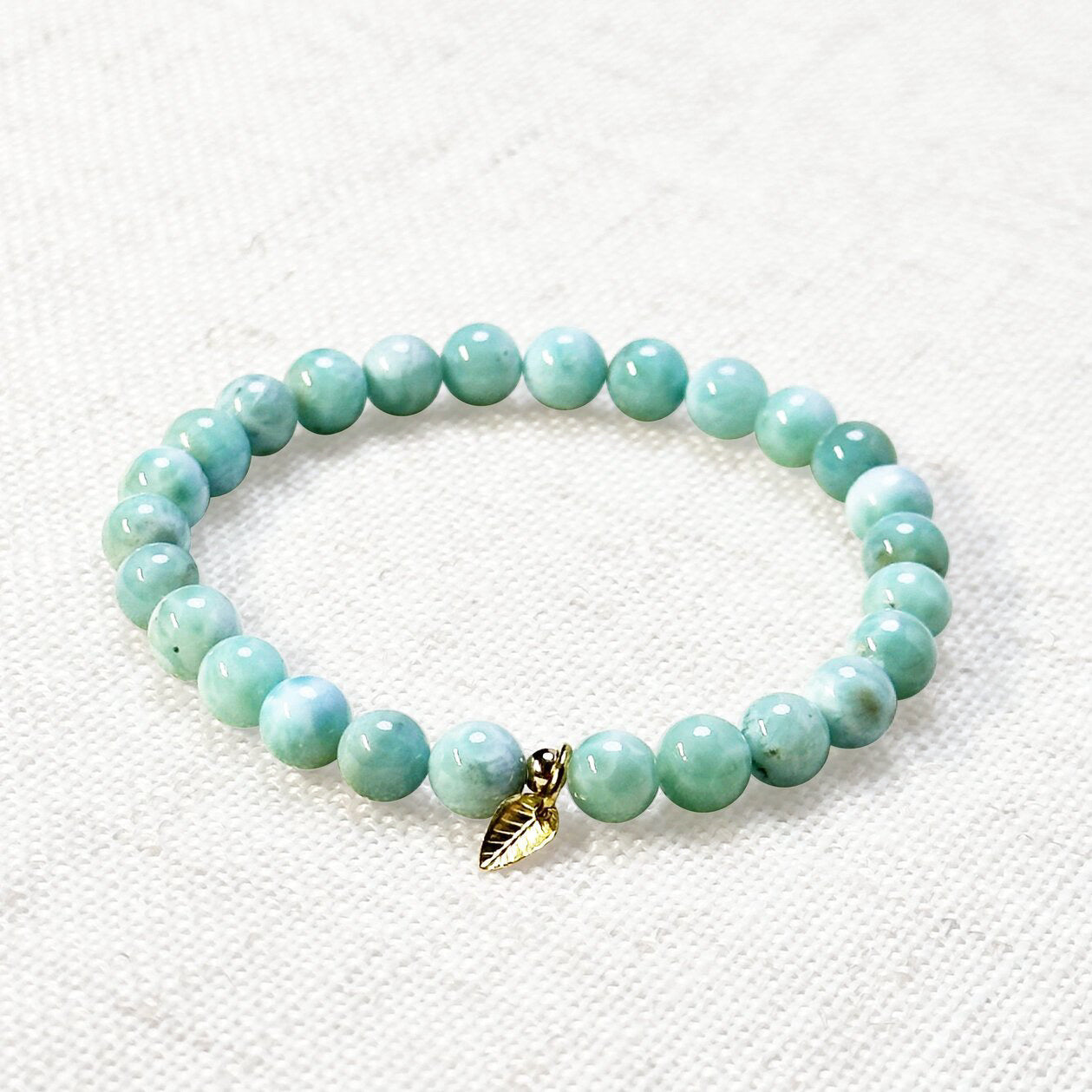 AAA larimar bracelet with 6mm ocean-blue beads and golden leaf charm